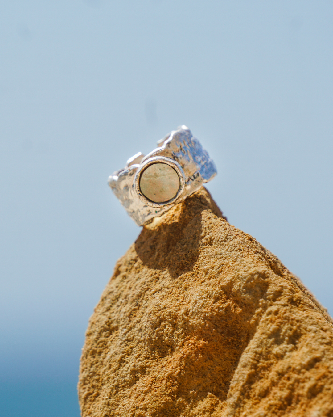 Anillo artesanal en plata, sobre roca frente al Pacífico.